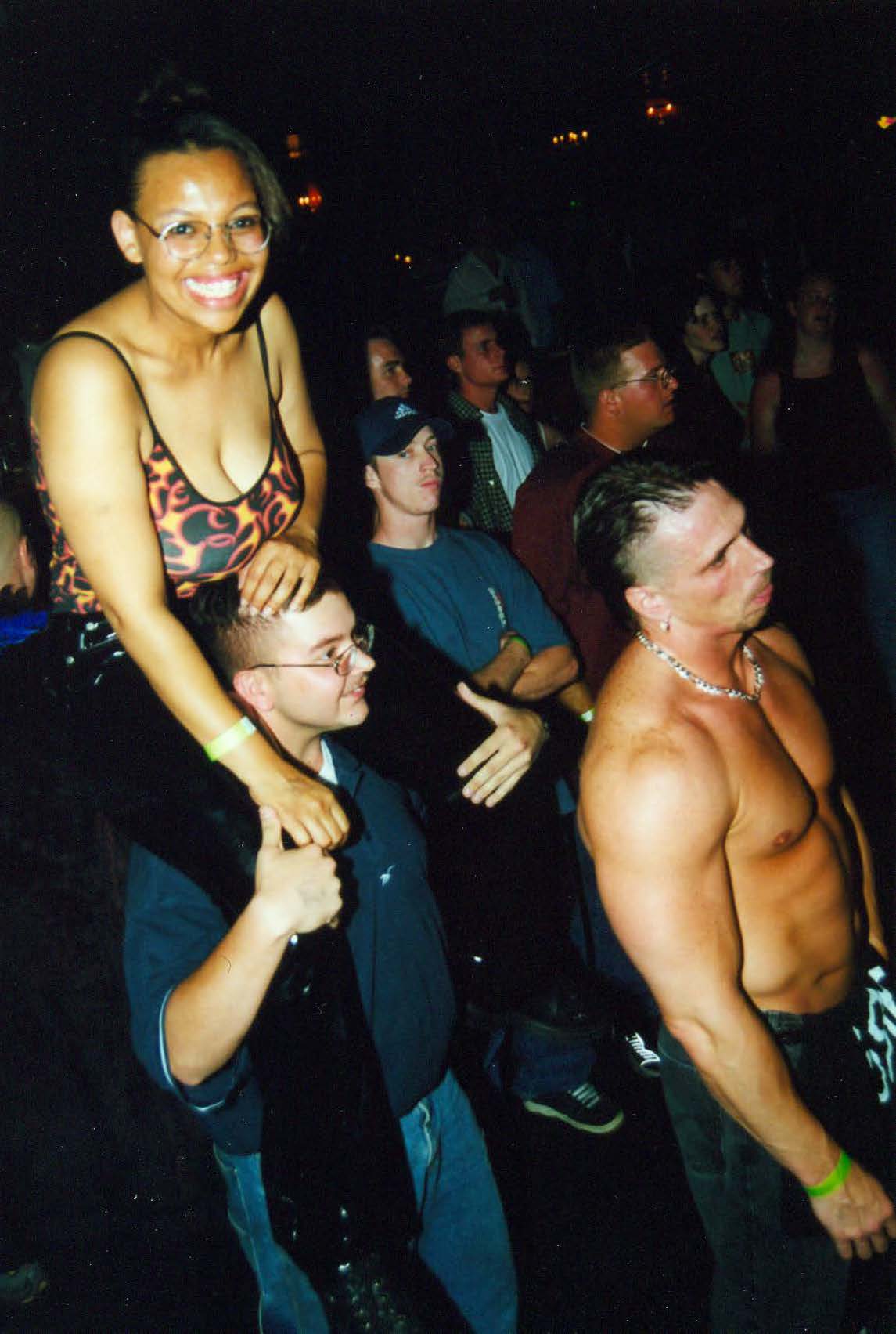 Woman on man's shoulders at crowded event
