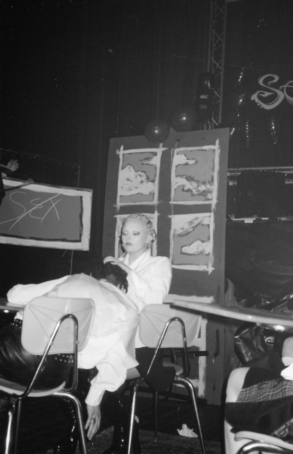 Performer with dramatic makeup cradling partner on stage